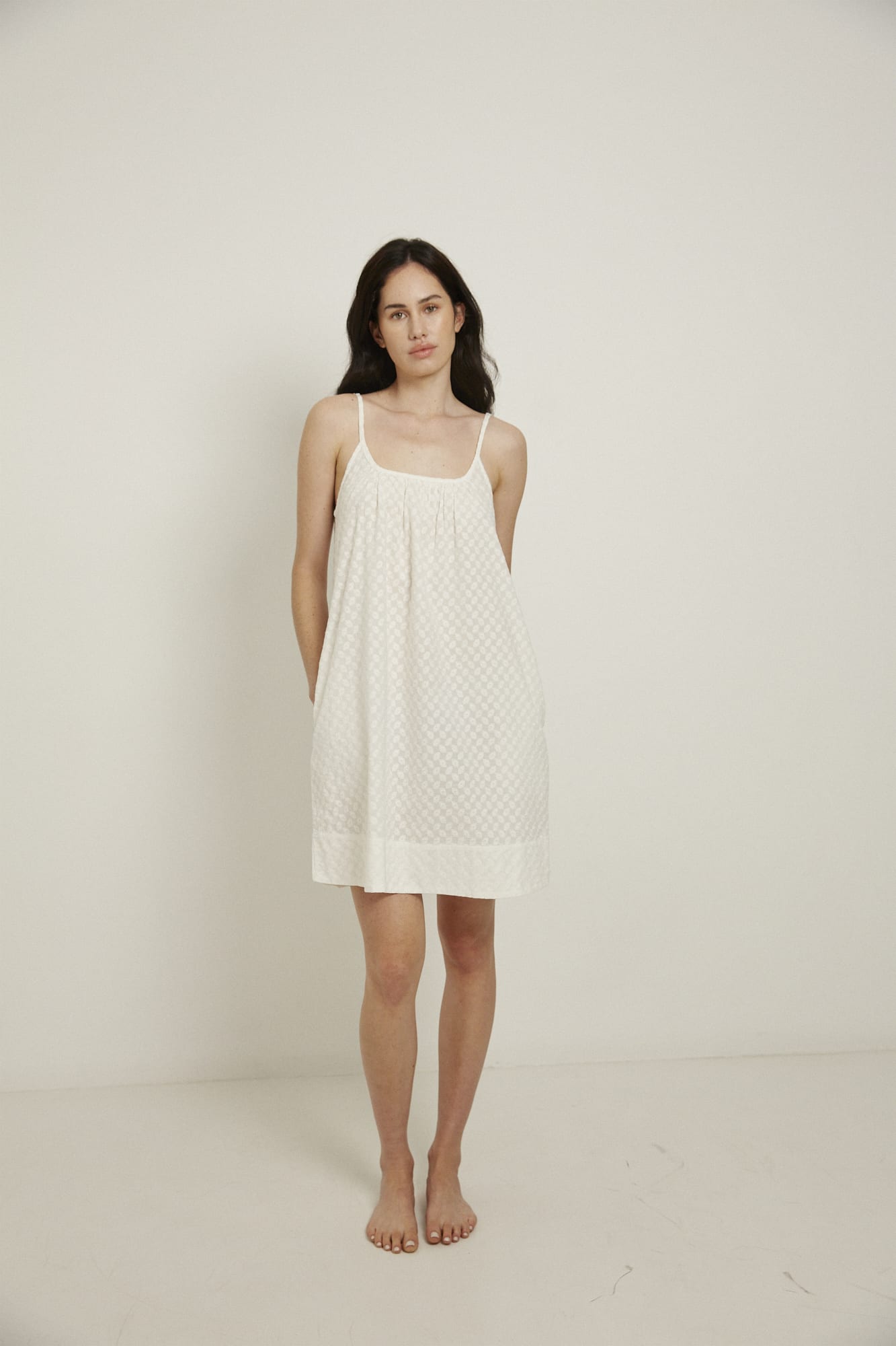 This knee length women’s nightdress dress features a scoop neck, adjustable spaghetti straps and side pockets. Finished with a wide hem, French seams, it is made from 100% organic cotton, in white, and features delicate all over embroidery.