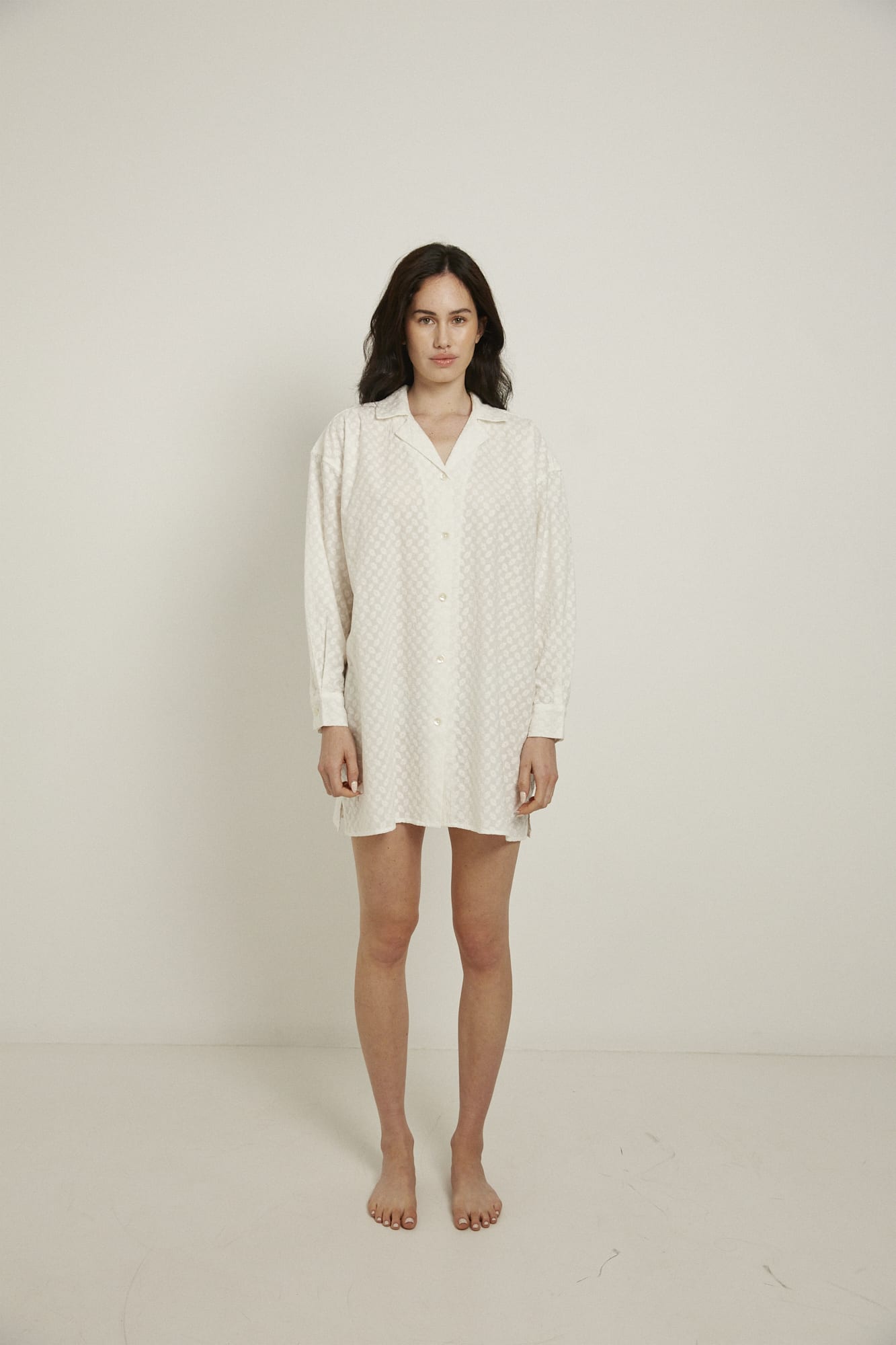 This knee length women’s nightdress dress has a boxy shape, with a comfortable dropped shoulder, and natural shell buttoned cuffs and placket.  Featuring a single breast pocket, back box pleat and locker loop detail, this shirt is finished with French seams. In white, and made from 100% organic cotton, this shirt is delicately embroidered all over.  