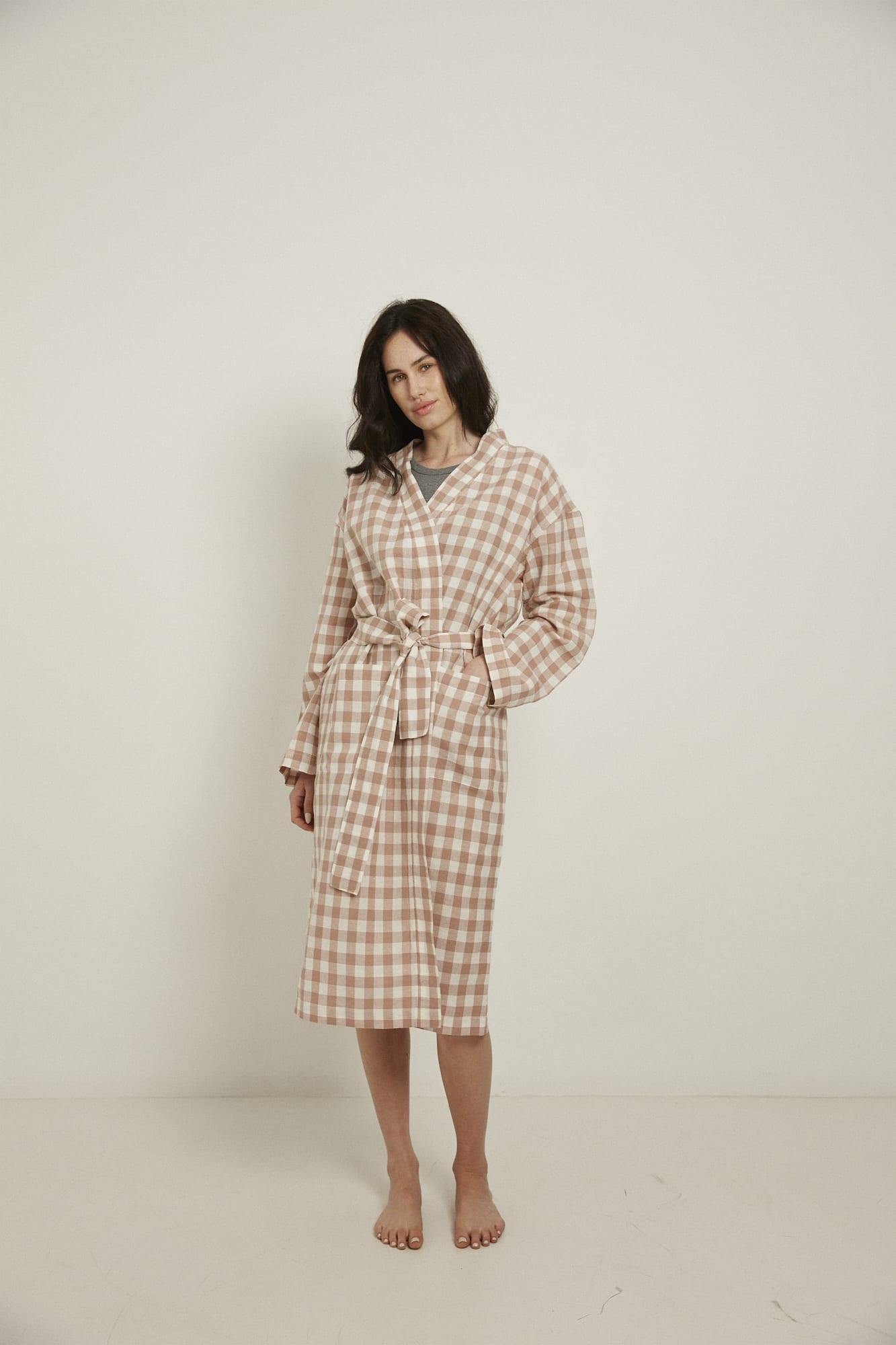 Women’s Robe.  Made from an organic cotton and linen blend, in a pink and white check.  This robe has a relaxed-fit with a dropped shoulder, front patch pockets and a tie belt. Finished with French seams.