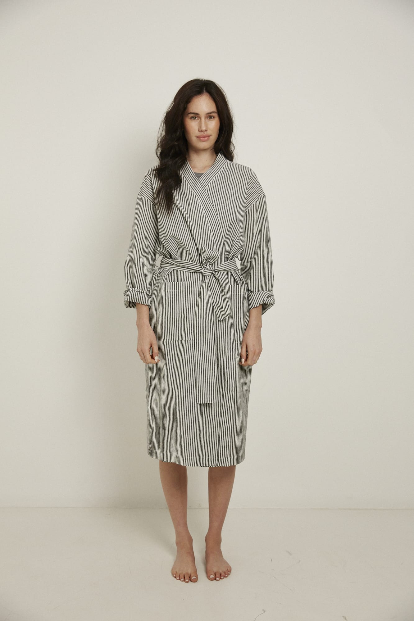 Women’s Robe.  Made from an organic cotton and linen blend, in a black and white stripe.  This robe has a relaxed-fit with a dropped shoulder, front patch pockets and a tie belt. Finished with French seams.