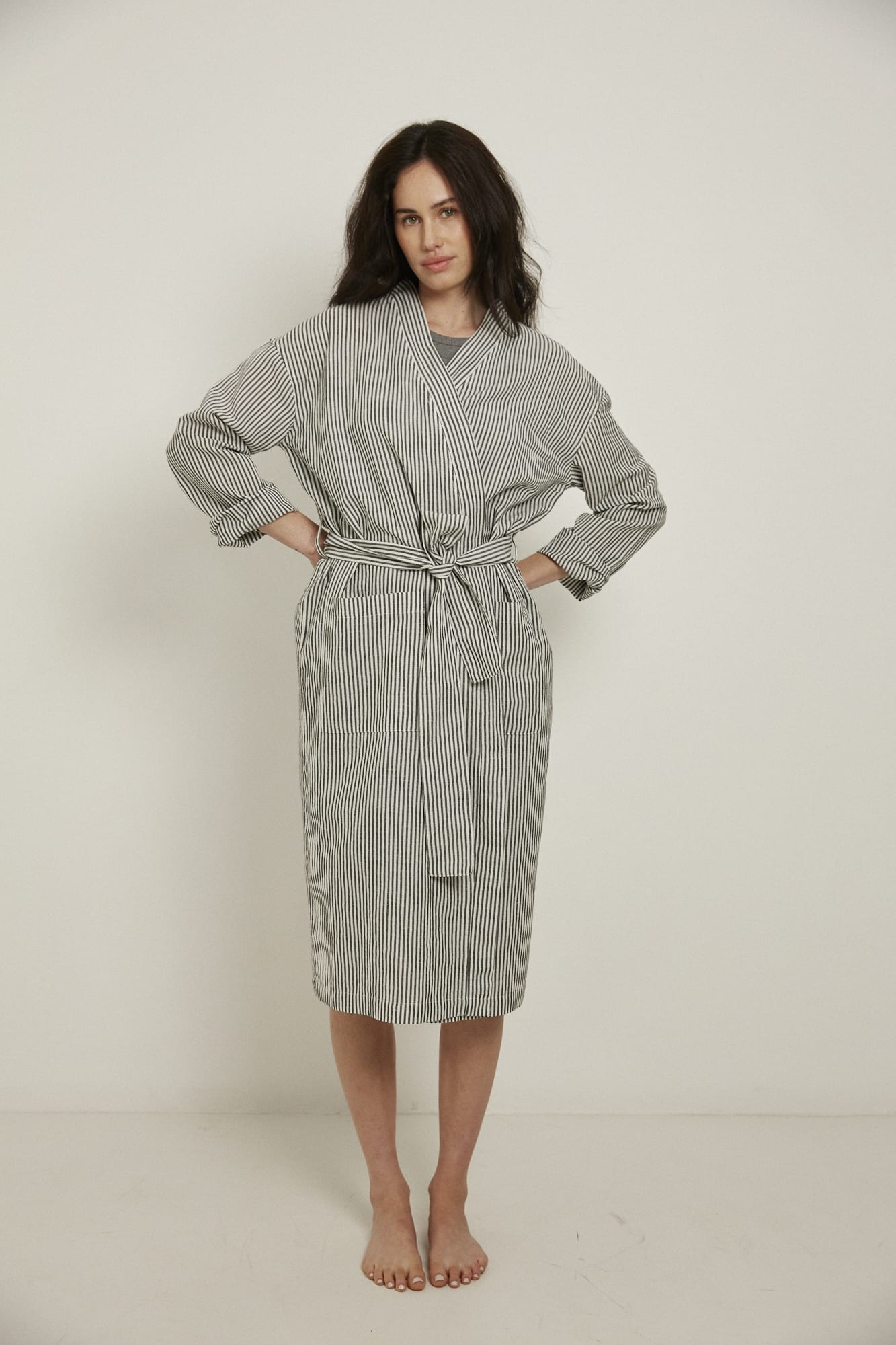 Women’s Robe.  Made from an organic cotton and linen blend, in a black and white stripe.  This robe has a relaxed-fit with a dropped shoulder, front patch pockets and a tie belt. Finished with French seams.