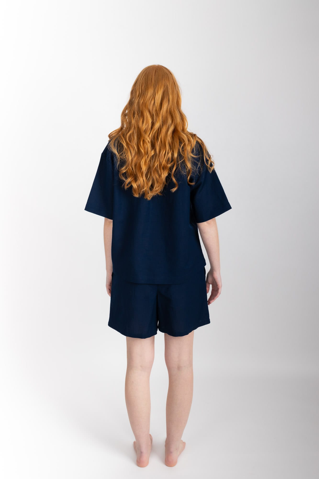 Women’s pyjama set including a short sleeve shirt and shorts. Made from an organic cotton and linen blend, in Navy.  The shirt has shell buttons, a front pocket and a back pleat with locker loop detail.  The shorts feature natural shell buttons and an elasticated waistband for comfort.