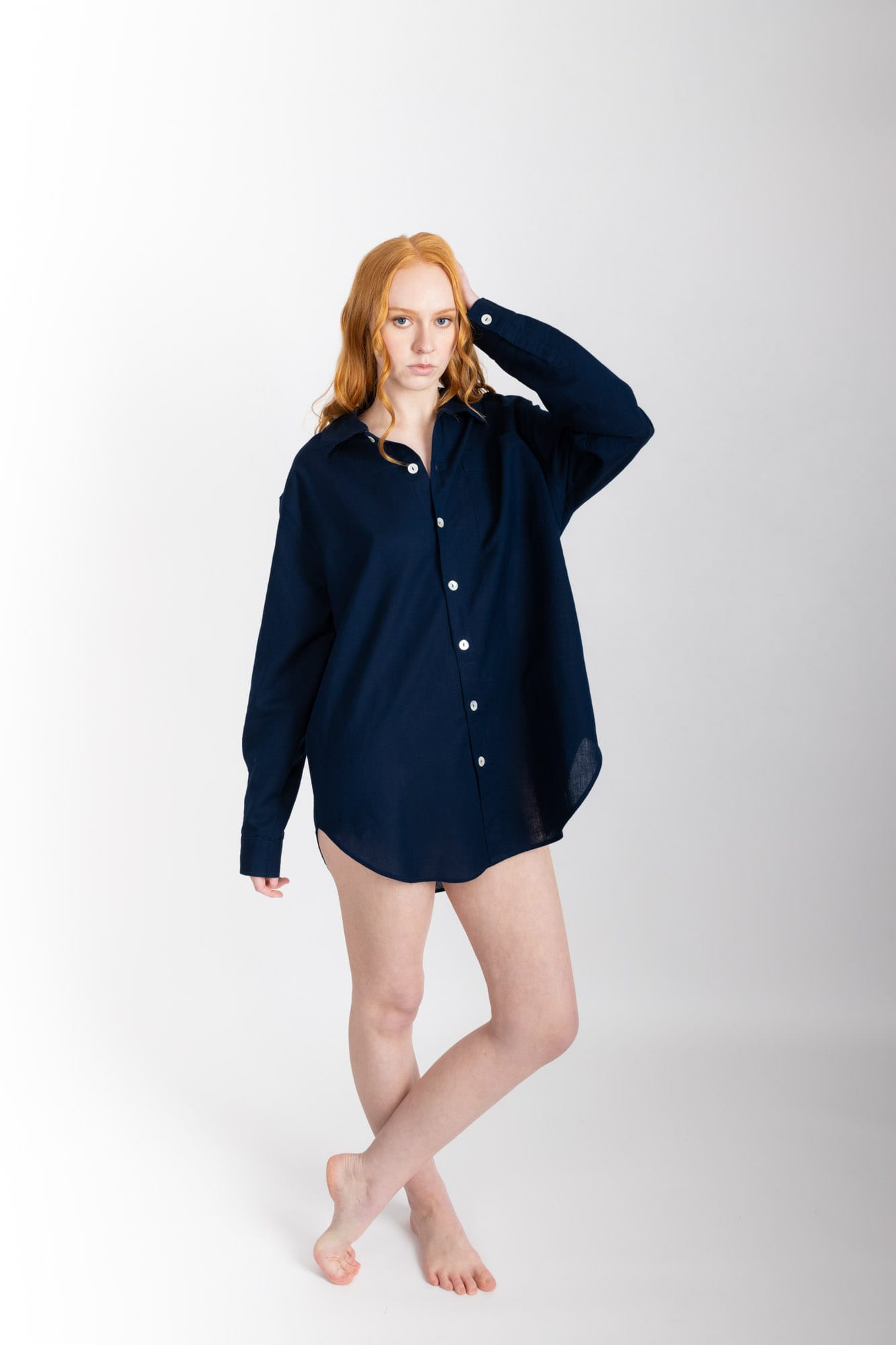 A classic man style shirt silhouette, lengthened, with a rounded hem and buttoned cuff. Featuring a single breast pocket, back box pleat and locker loop detail, and natural shell buttons.  In navy, and made from a blend of 55% organic cotton 45% linen, this shirt is finished with French seams.