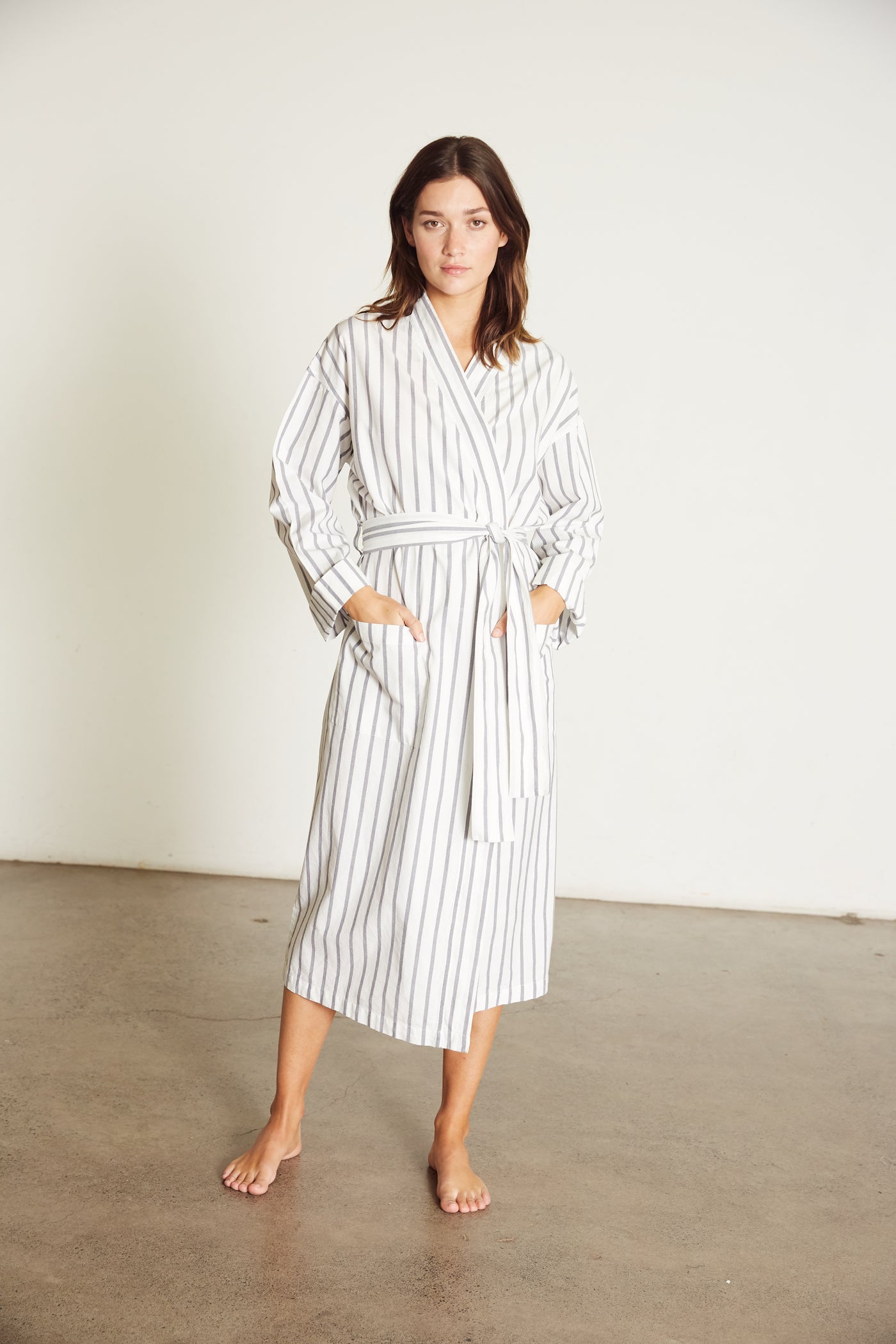 Women’s Robe.  Made from 100% organic cotton.  White, with a navy stripe.  This robe has a relaxed-fit with a dropped shoulder, front patch pockets and a tie belt. Finished with French seams.