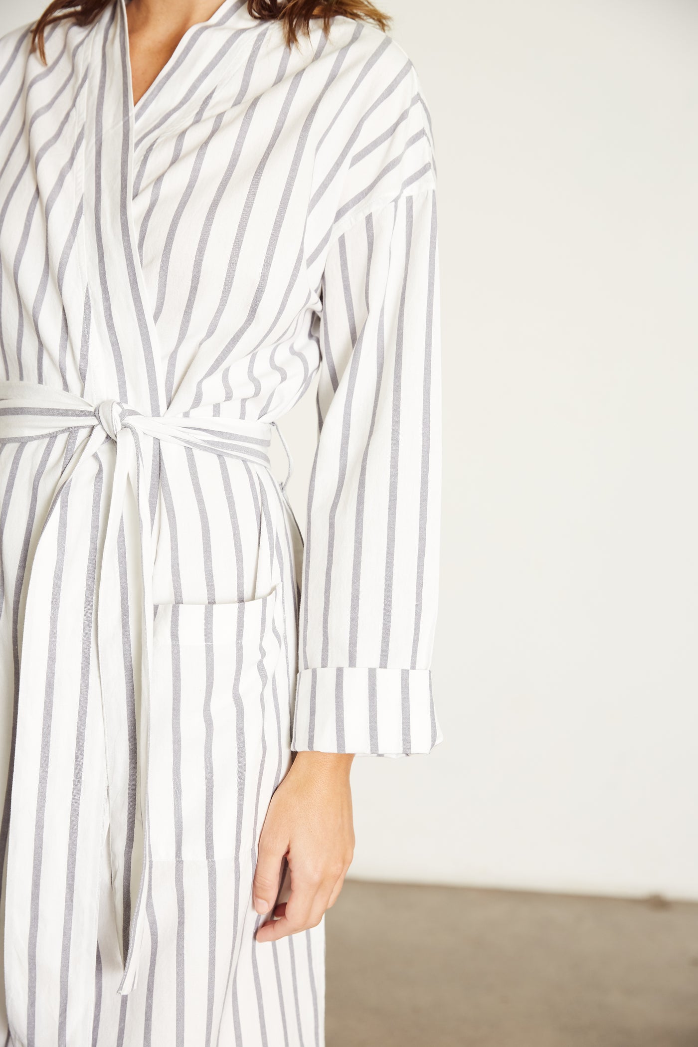 Women’s Robe.  Made from 100% organic cotton.  White, with a navy stripe.  This robe has a relaxed-fit with a dropped shoulder, front patch pockets and a tie belt. Finished with French seams.